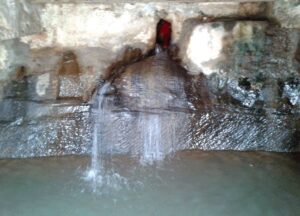 Sacred Hanuman Dhara waterfall with natural rock formation and flowing water near a Resort in Chitrakoot